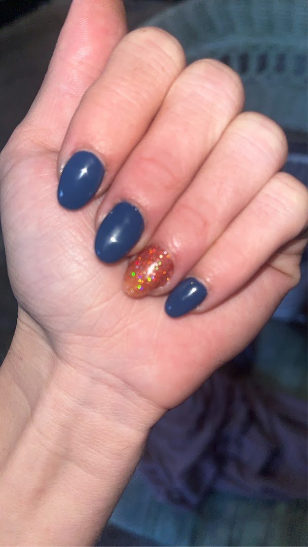 Polished nails beside bottled polish colors
